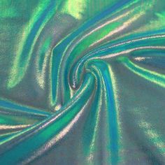 a close up shot of a shiny green fabric with blue and silver lines on it