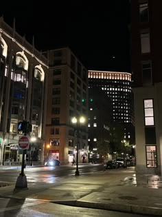 an empty city street at night with buildings in the background