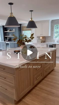 a large kitchen with an island in the middle and two pendant lights hanging from the ceiling