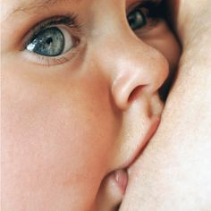 a close up of a child's face being kissed by another person with blue eyes