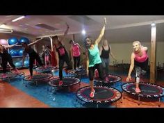 a group of women doing exercises on trampolies in a gym with exercise mats