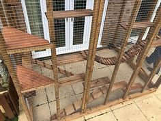 a caged in outdoor area with chairs and tables on the ground next to a window