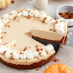 there is a cake with white frosting on the plate and an orange pumpkin in the background