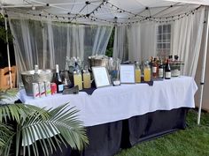 a table with drinks and menus under a tent