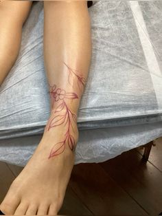 a woman's foot with a flower tattoo on her left leg and the bottom part of her legs