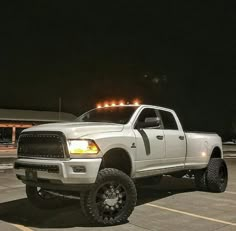 a white ram truck parked in a parking lot at night with lights on the roof