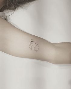 a woman's arm with a small elephant tattoo on the left side of her arm