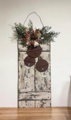 an old door is decorated with flowers and greenery to hang on it's side