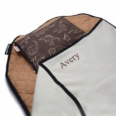 an oven mitt with the name avery printed on it, sitting next to a brown and white oven mitt