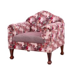 a pink chair with floral fabric and wooden legs