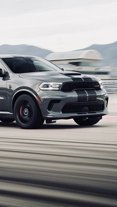 a gray dodge duran is driving down the road