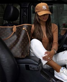 a woman sitting in the back seat of a car with her hand on her hip