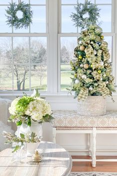 a decorated christmas tree sitting in the corner of a living room next to a window