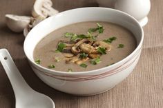 a bowl of soup with mushrooms and parsley