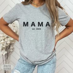 a woman wearing a grey shirt with the words pregnant af on it