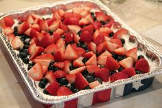 a red, white and blue dessert with strawberries on top in a tin pan