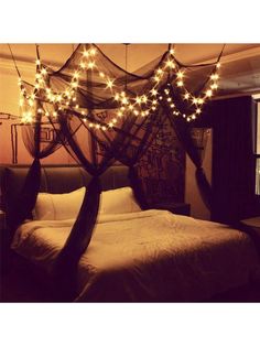 a canopy bed with lights hanging from it's sides