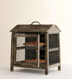 an old wooden cabinet with wire mesh doors and two trays on the top shelf