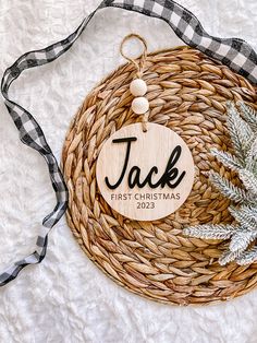 a personalized wooden ornament on a wicker basket with a black and white checkered ribbon