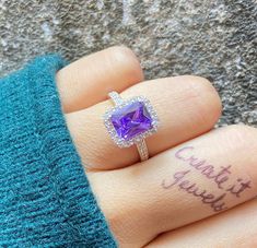 a woman's hand with a purple ring on it