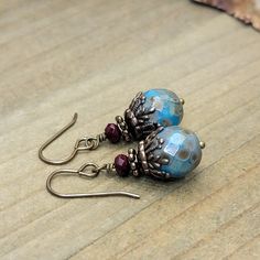 These Rustic Boho Turquoise Czech Dangle Earrings are delicately hand crafted from turquoise and deep red Czech glass beads, with beautiful brass accents. They capture a rustic, boho style, with an ornate finish. Uniquely gorgeous! Turquoise faceted Czech glass beads Deep red faceted Czech glass beads Vintaj antiqued brass accents Antiqued brass ear hooks Drop 1.5" Created in studio - Wilmington, NC Boho Turquoise, Turquoise Boho, Rustic Jewelry, Rustic Boho, Jewelry Design Earrings, Wilmington Nc, Design Earrings, Brass Accents, Ear Hook