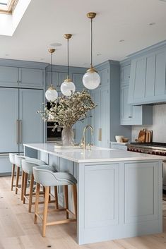 a large kitchen with blue cabinets and white counter tops, an island in the middle