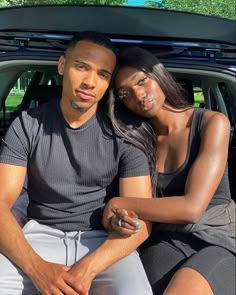 a man and woman sitting in the back of a car with their arms around each other