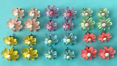 six pairs of flower shaped earrings on a blue background