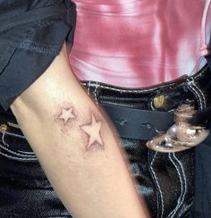 a woman's arm with three stars tattooed on the left side of her arm