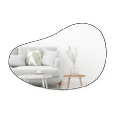 a white couch sitting in front of a mirror on top of a wooden coffee table