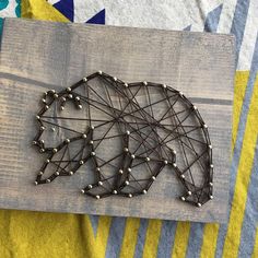 a string art bear on a wooden board