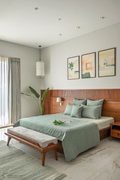 a bedroom with a bed, nightstands and pictures on the wall