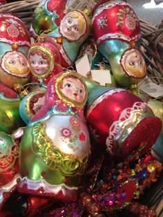 a basket filled with lots of colorful christmas ornament ornaments on top of a table