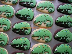 cookies decorated with green and black icing in the shape of chameleons