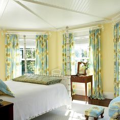 a bedroom with yellow walls and blue curtains