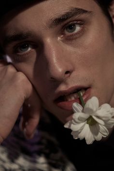 a man with a flower in his mouth