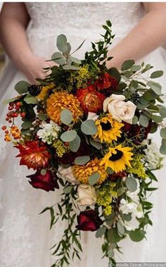 a bridal holding a bouquet of flowers and greenery