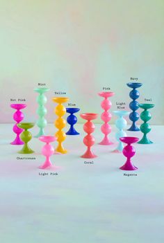 an assortment of different colored candlesticks on a white surface with the names of each candle