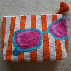 an orange and white striped bag with sunglasses on it