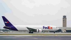 a fedex airplane sitting on the tarmac at an airport