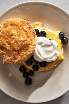 a white plate topped with an apple pie and blueberries next to a pastry on top of it