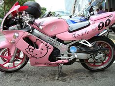 a pink hello kitty motorcycle parked on the street