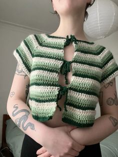 a woman wearing a green and white crochet top