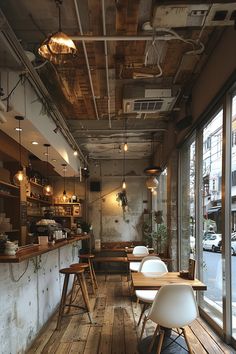 the interior of a restaurant with wooden tables and chairs in front of large windows that look out onto an urban street