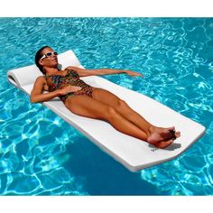 a woman laying on an inflatable mattress in a swimming pool with her legs spread out