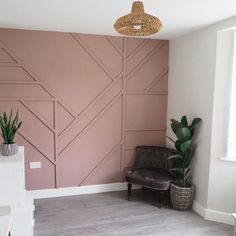 a living room with pink walls and wood paneling on the wall, potted plants in front of it