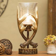 an antler lamp sitting on top of a table next to a vase with flowers