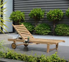 a wooden chaise lounge chair sitting on top of a patio