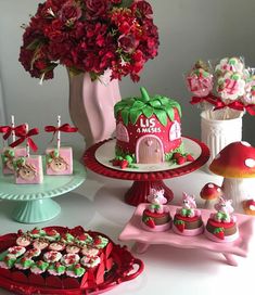 a table topped with cakes and cupcakes covered in frosting