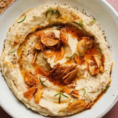 a white bowl filled with hummus and toasted bread